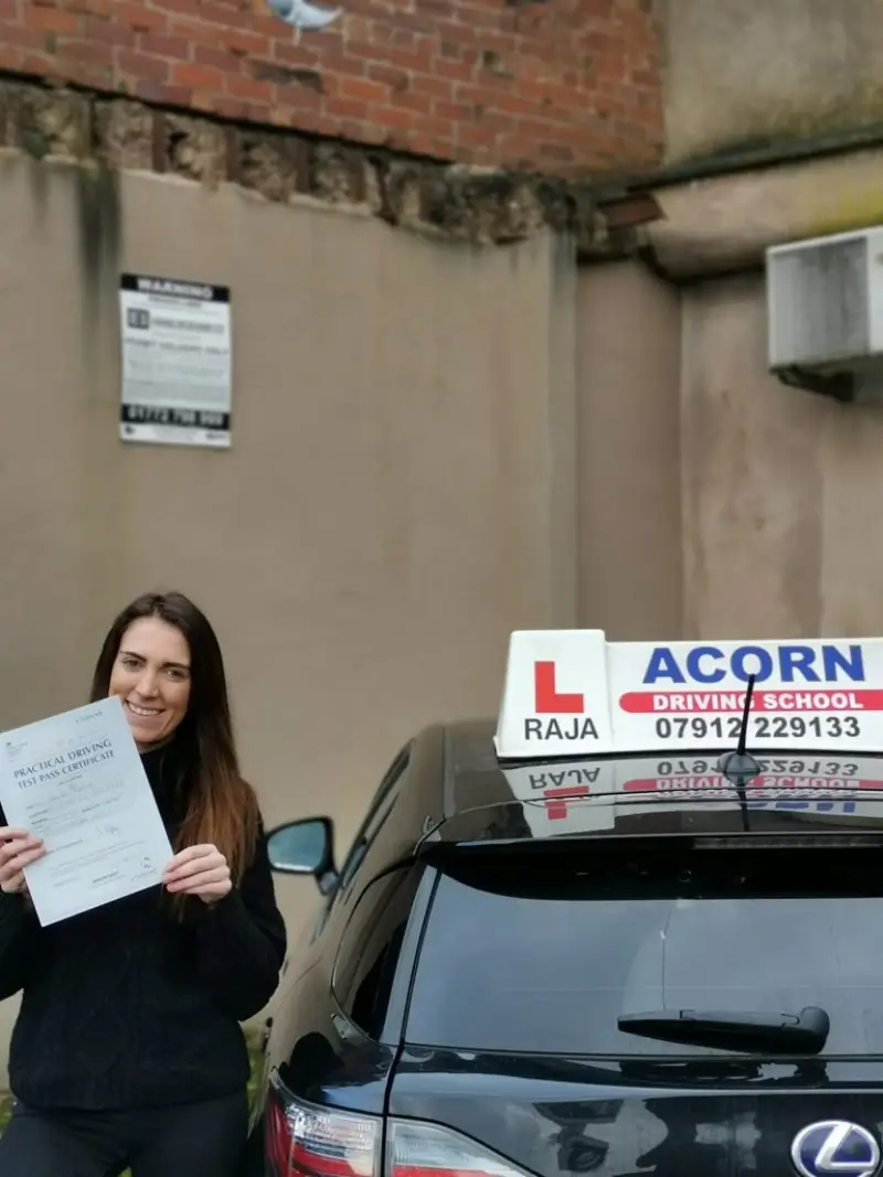 Student proudly showing driving test pass certificate in Blackburn